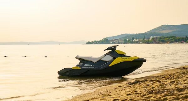tiendas de motos de agua - una moto acuática amarilla y negra estacionada en la orilla de una playa