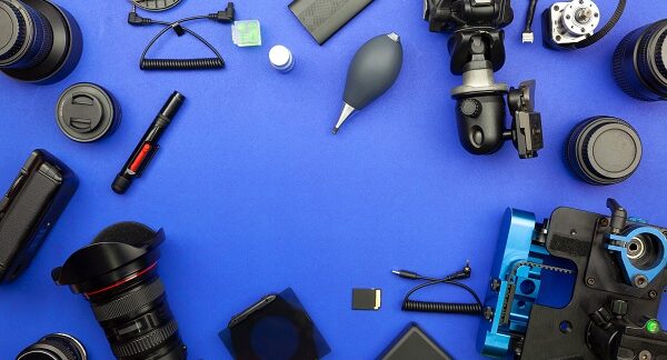 una de las mejores tiendas de cámaras, en un fondo azul, donde reposa un cámara, con diferentes accesorios que complementan la experiencia