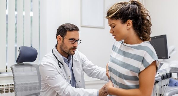 mejores nefrólogos - uno de los mejores nefrólogos, examina a paciente femenina con dolor en la zona de los riñones