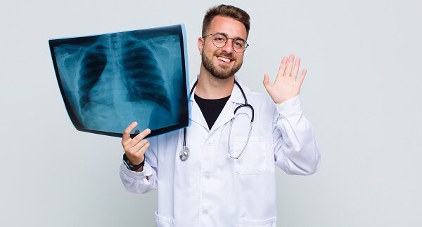 mejores neumólogos - uno de los mejores neumólogos, sostiene un radiografía hecha en tórax de un paciente donde destacan los pulmones