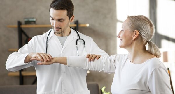 mejores reumatólogos - uno de los mejores reumatólogos, hace un examen del sistema musculoesquelético a paciente femenina de edad adulta