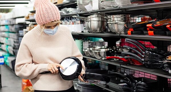 en una de las tiendas de utensilios de cocina baratos, una mujer revisa un sarten
