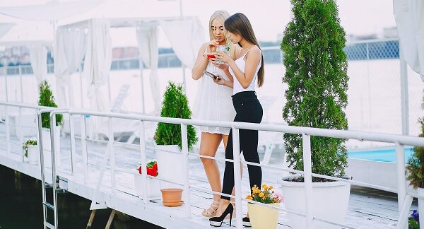 una de las azoteas para comer y beber, dos mujeres disfrutan de bebidas, mientras están viendo algo en su teléfono