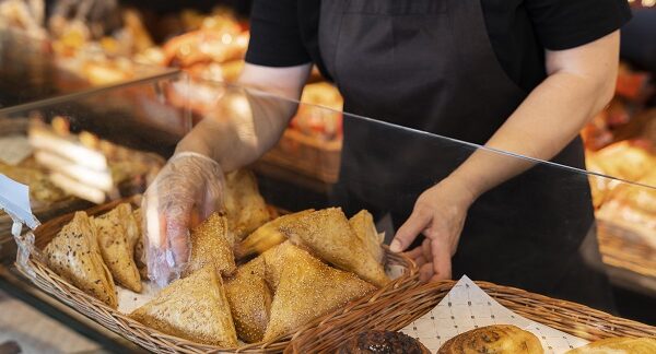 una de las mejores panaderías tradicionales, una persona pone en un exhibidor una serie de panes