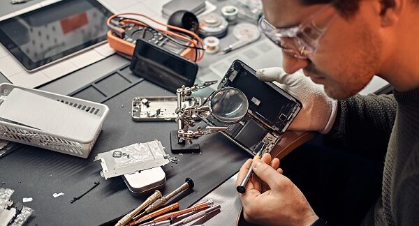 en uno de los centros de reparación de celulares, un técnico destapa un teléfono para descubrir la falla