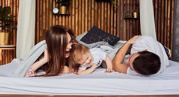 de los hoteles para familias, una familia esta recostada en la cama de un hotel