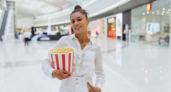 en uno de los centros comerciales con cine, una mujer joven posa con una crispetera