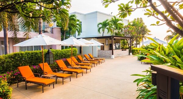 uno de los mejores hoteles boutique, visto desde el frente donde se nota su fachada, además de una sillas con paraguas al frente