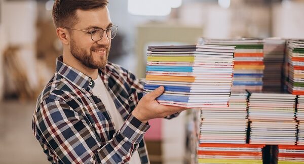mejores editoriales - un hombre sostiene una serie de libros recién impresos